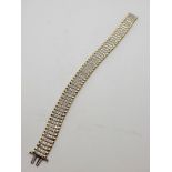 A continental 10k yellow and white metal diamond set line bracelet, the diamonds set in rows of