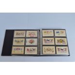 An album containing over 200 silk postcards, mostly early 20th century examples