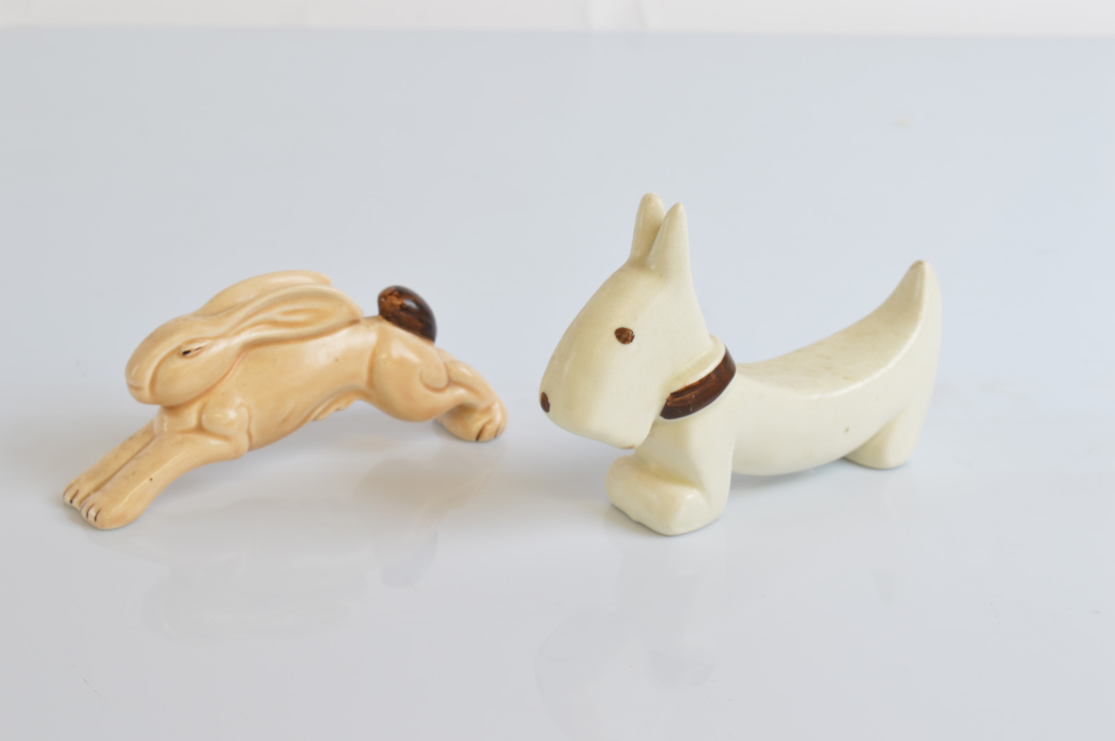 An Art Deco pottery figure of a leaping hare, in two tones of brown, 13cm together with a cream