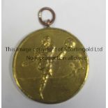 FOOTBALL MEDAL A 3.5cms round gold coloured medal showing a footballer kicking a ball with a beach