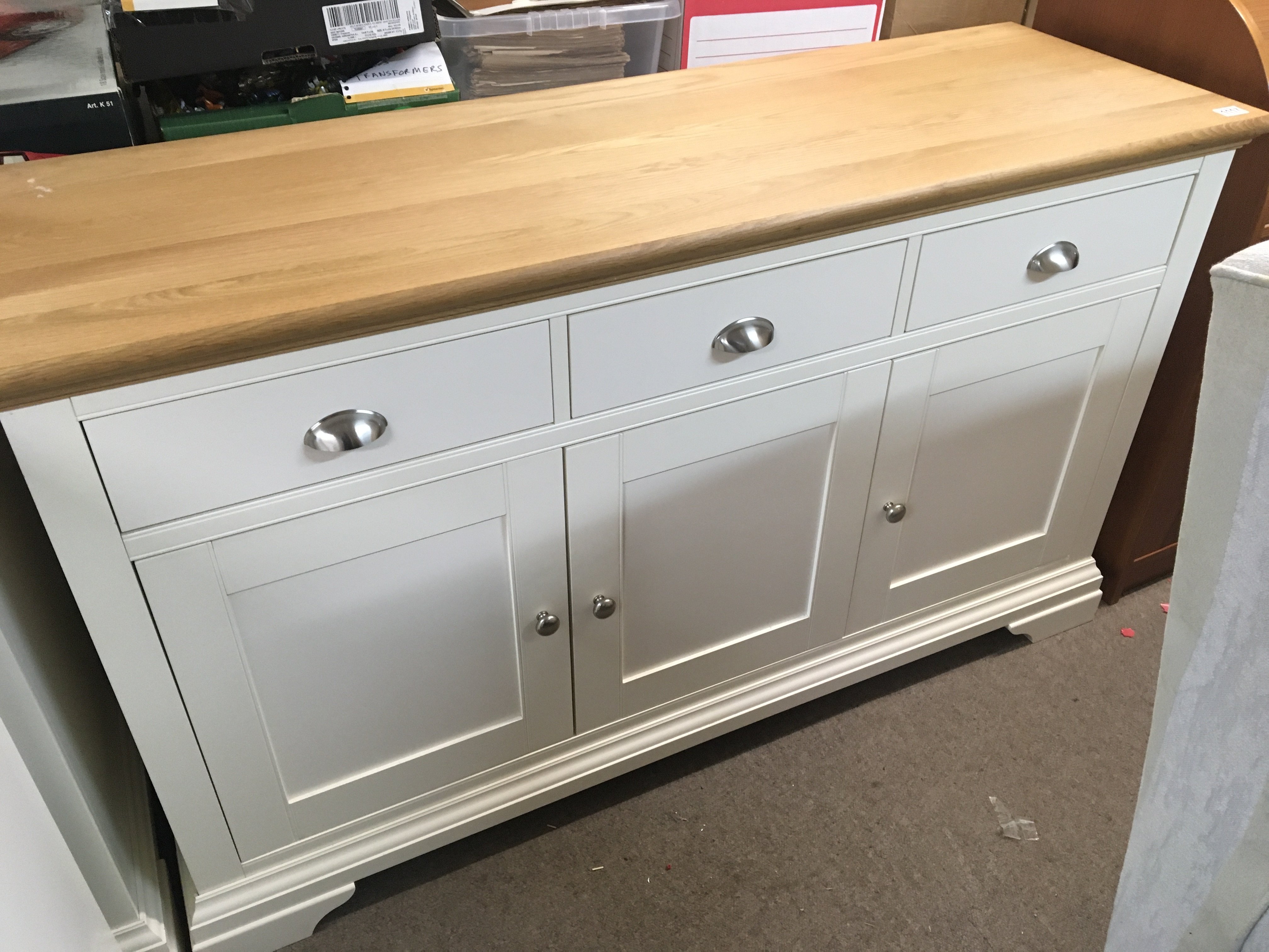 A modern white band light oak cabinet with a rectangular top above three drawers with cupboards unde