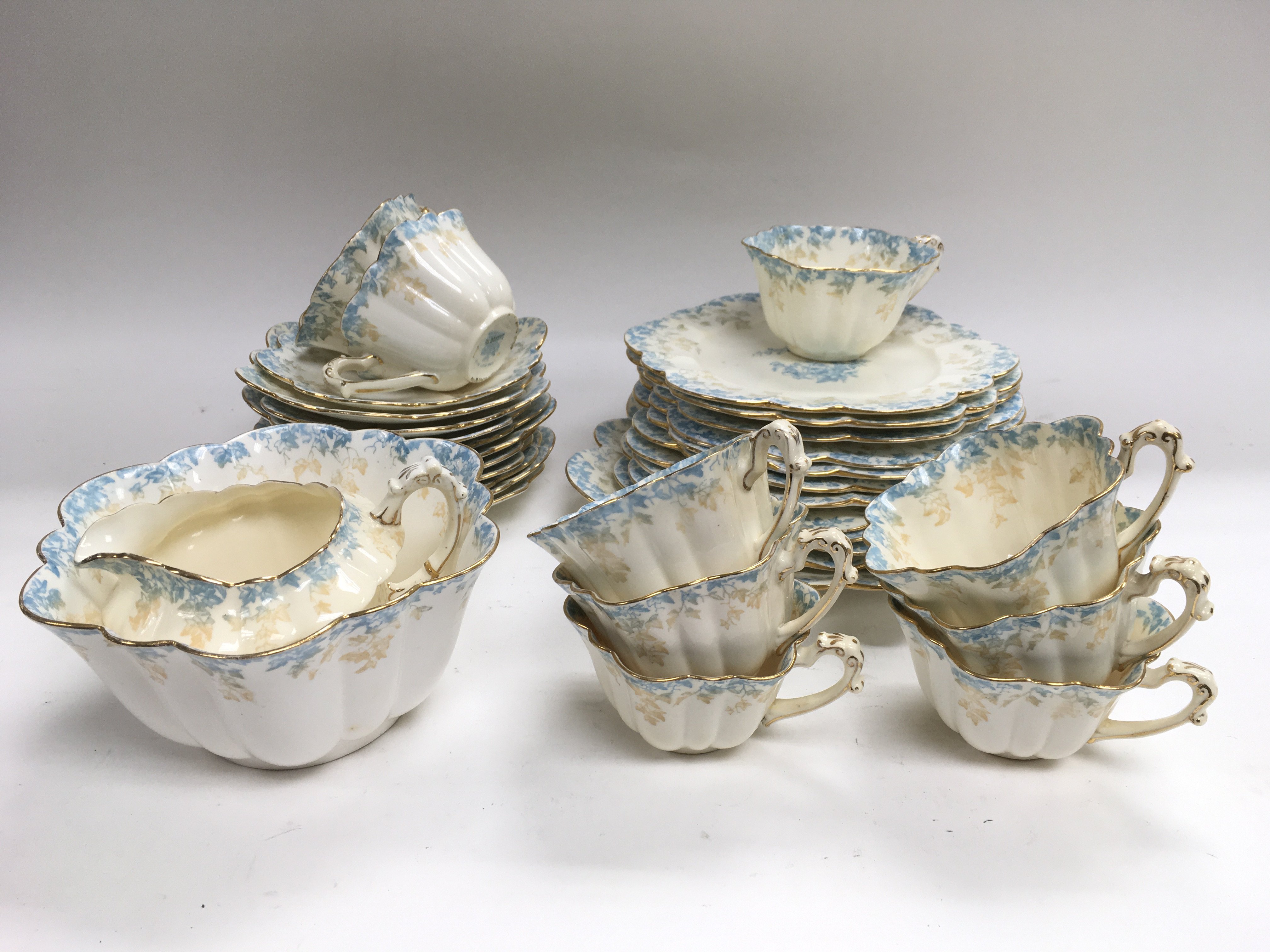 A scalloped tea set blue and gilt decoration on a