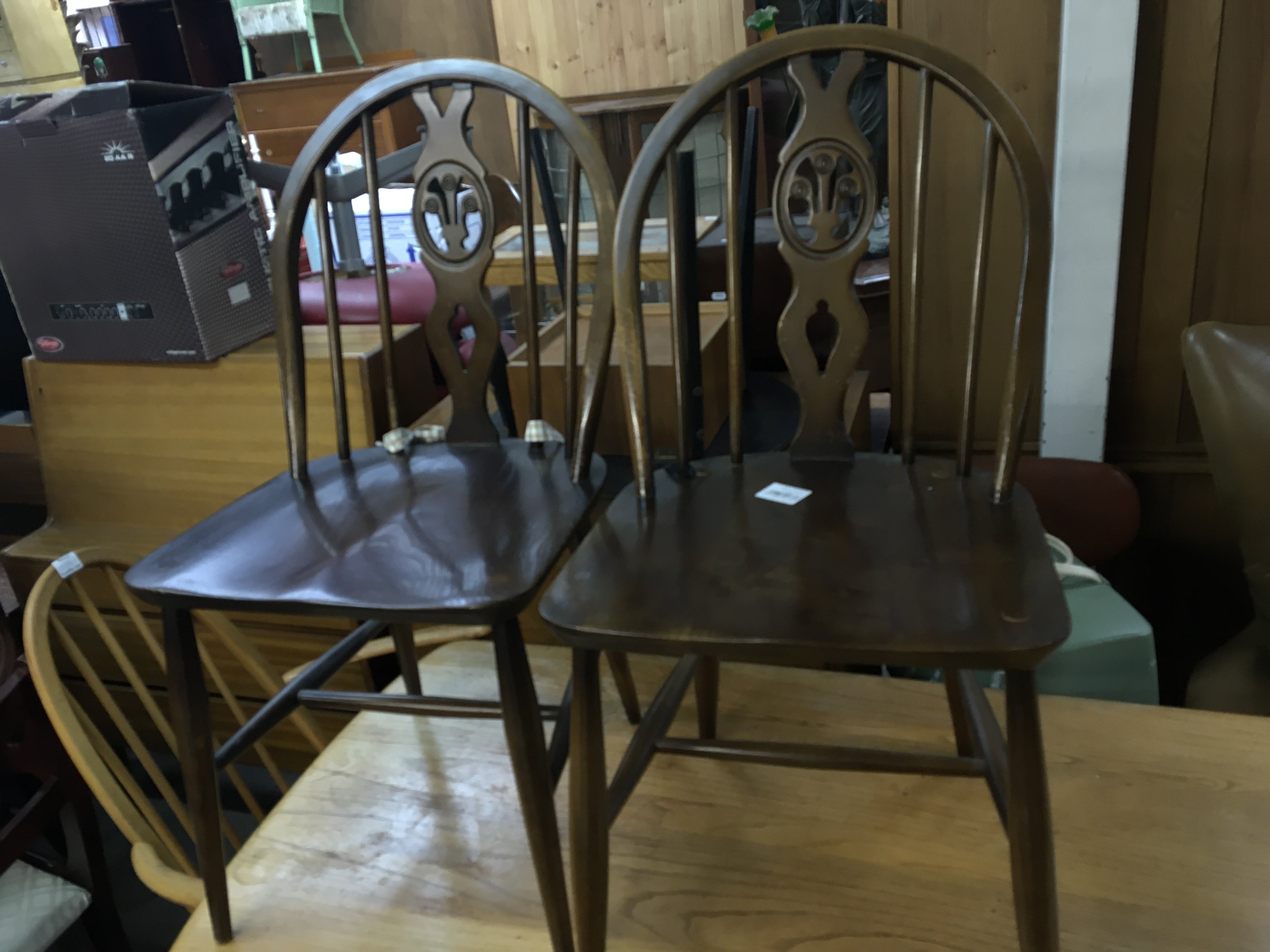 A set of four Ercol cottage style dining chairs with shaped backs and solid seats (4)