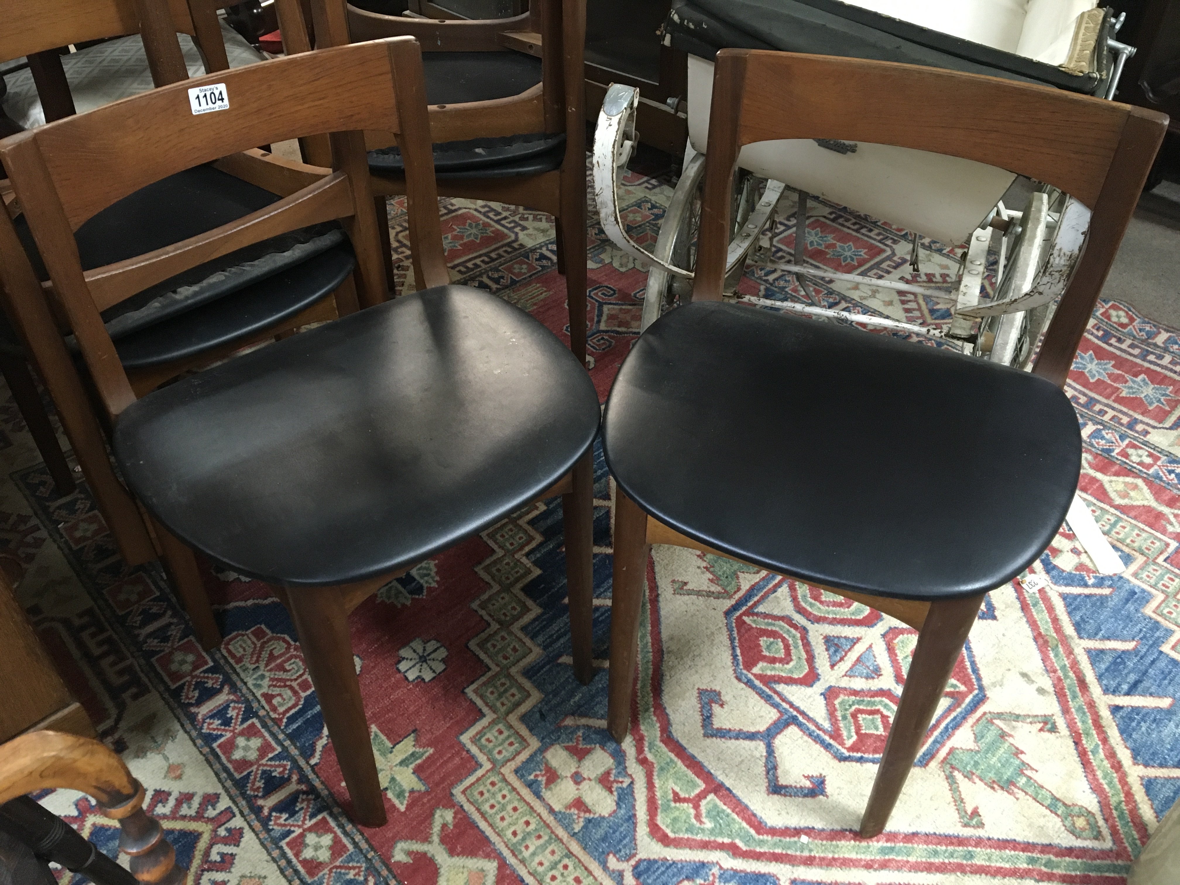 A set of modern teak dining chairs maker Nathan with black covered seats. (6)