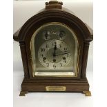 An arch topped oak cased clock with silvered chapt