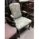 An open armchair with floral upholstery and raised