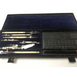 A cased draftsman set fitted in a tin case .