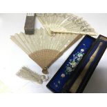 Two vintage fans including a carved sandalwood fan with silk embroidery in a fitted box and one