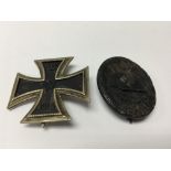 A German Imperial iron cross (polished back) and a wound badge. (2)