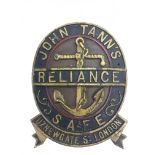 A metal crest emblem for a safe, makers John Tann