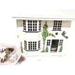 A dolls house with a sliding front and accessories