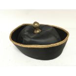 A Chinese Mandarin Ceremonial hat with gold braid the black silk hat with an ornate brass finial.