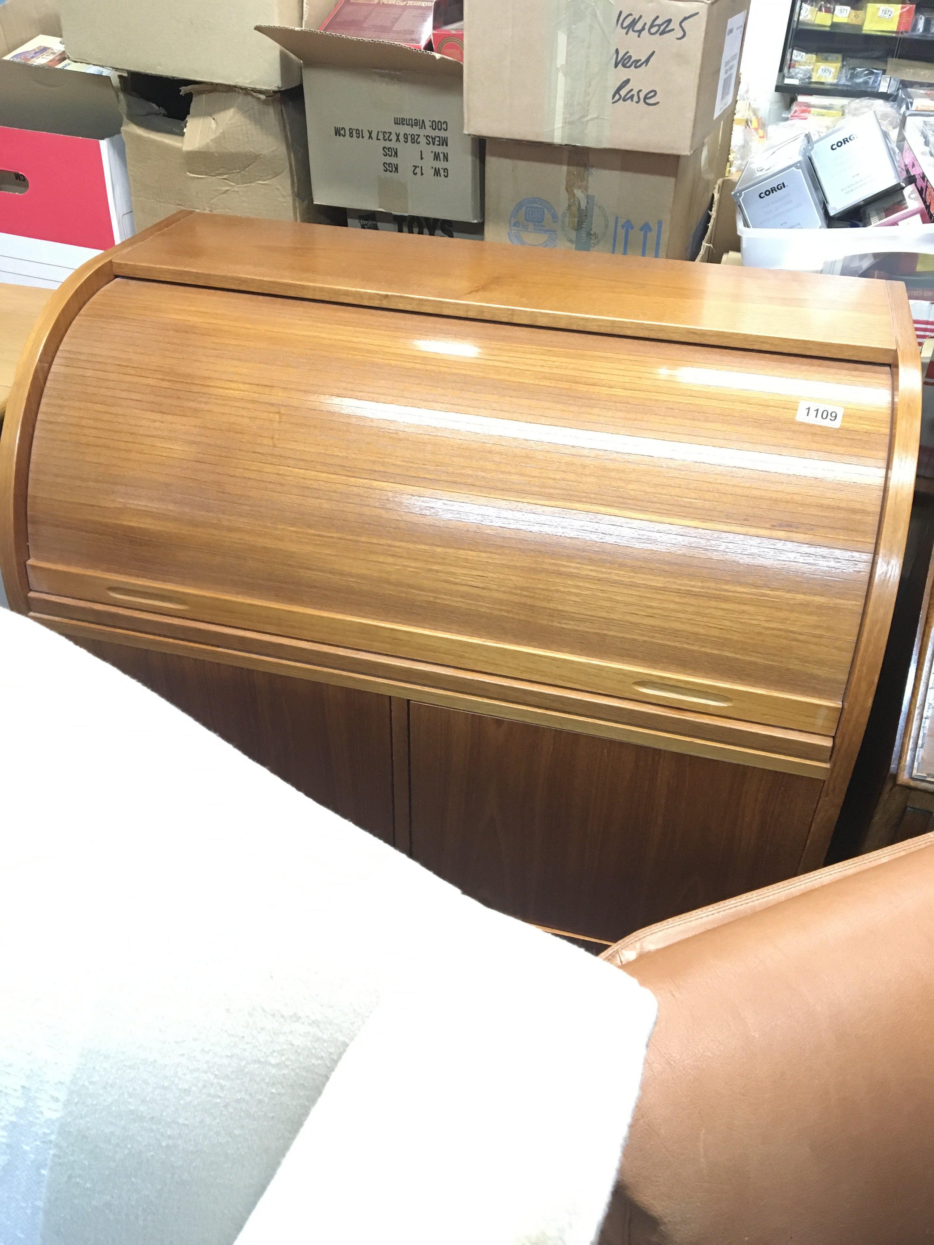 A modern teak roll top desk with a fitted interior