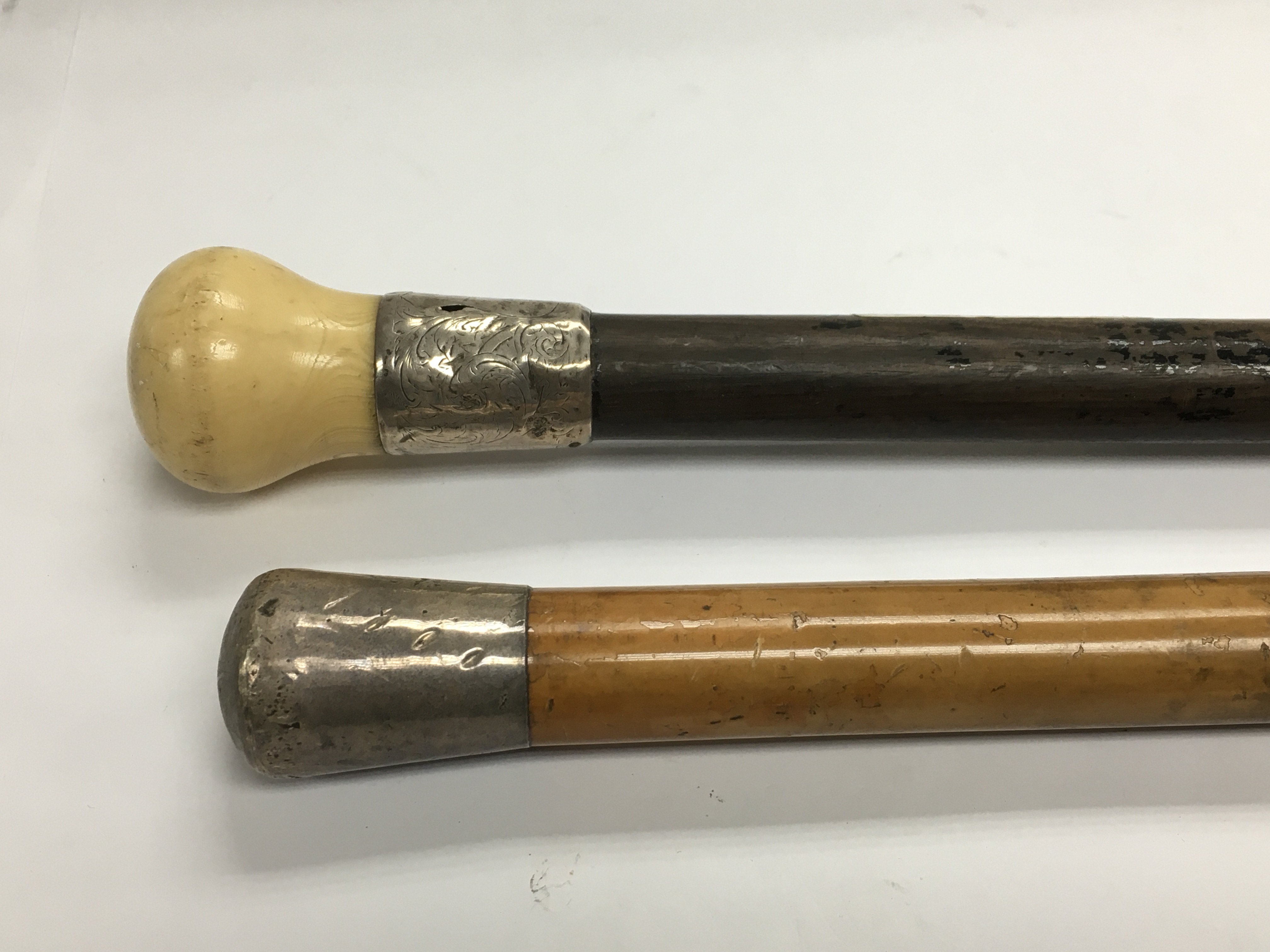 A Victorian ebony and ivory walking cane with silv