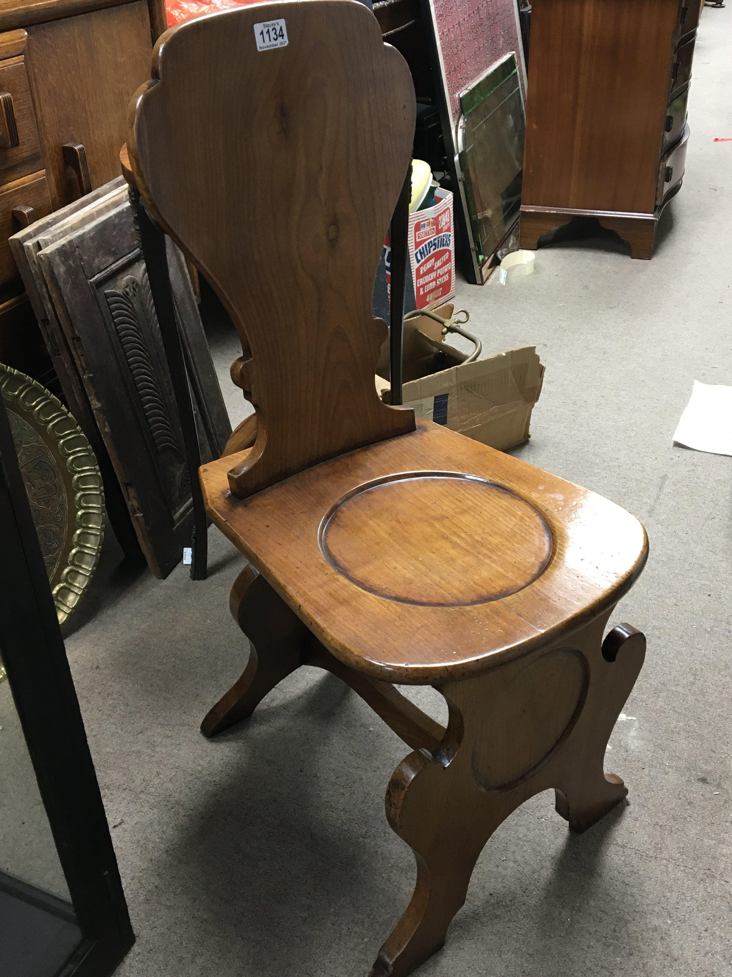 A continental late 19th century Elm hall chair with shaped supports and solid seat