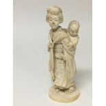 A late 19th century ivory carving of a woman carrying a young child some damage height 19cm