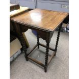 An oak side table with barley twist supports, approx 45.5cm x 45.5cm x 72.5cm.