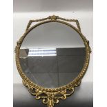 A small gilt wall mirror with classical influences