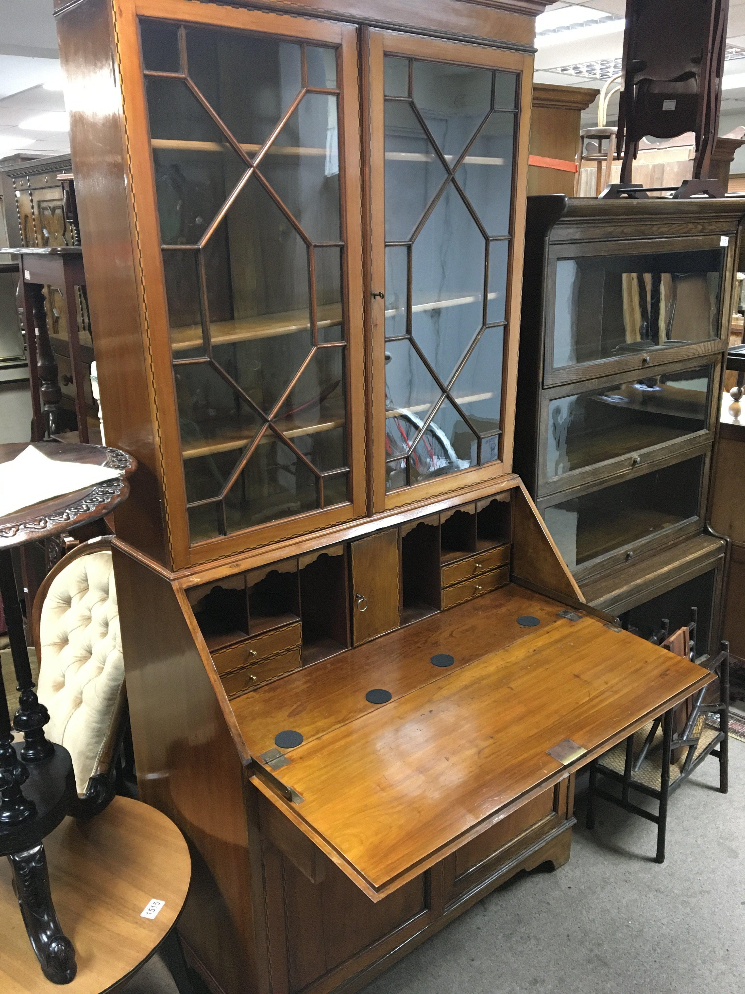 An Edwardian inlaid walnut bureau bookcase with glazed doors above a well fitted interior.
