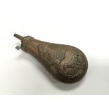 A copper shot flask depicting a hunting dog and pr