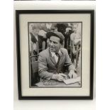A framed and glazed signed photo of Norman Wisdom, total approx size 30cm x 35cm.