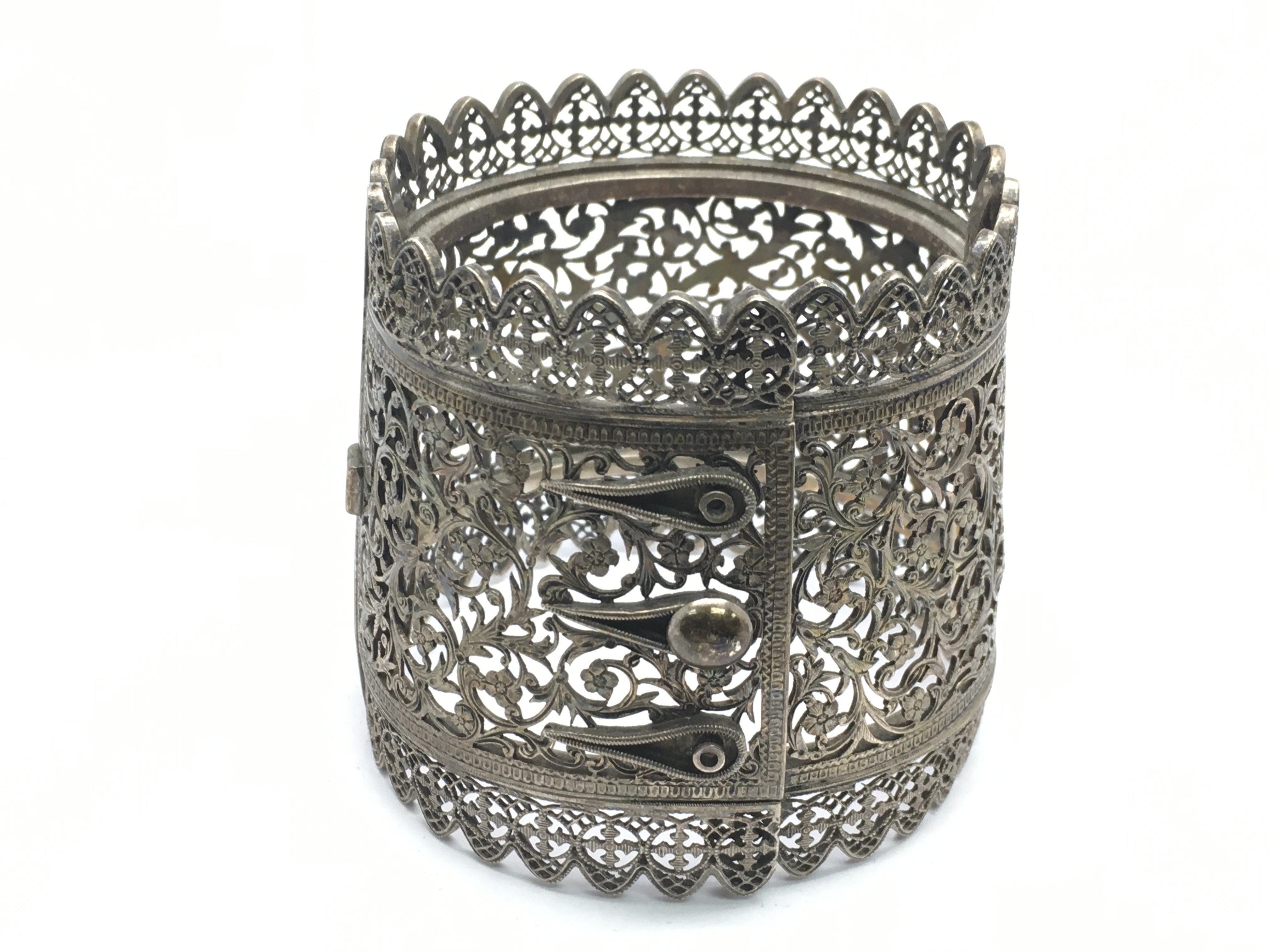 A silver bangle with pierced decoration.