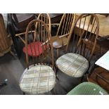 A pair of Ercol dining chairs with solid seats on