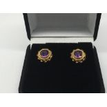 A pair of 9ct gold earrings set with amethyst
