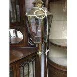A brass standard lamp with scroll supports.