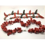 Two red coral necklaces, one with silver clasps.