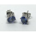 A pair of silver studs set with tanzanite.