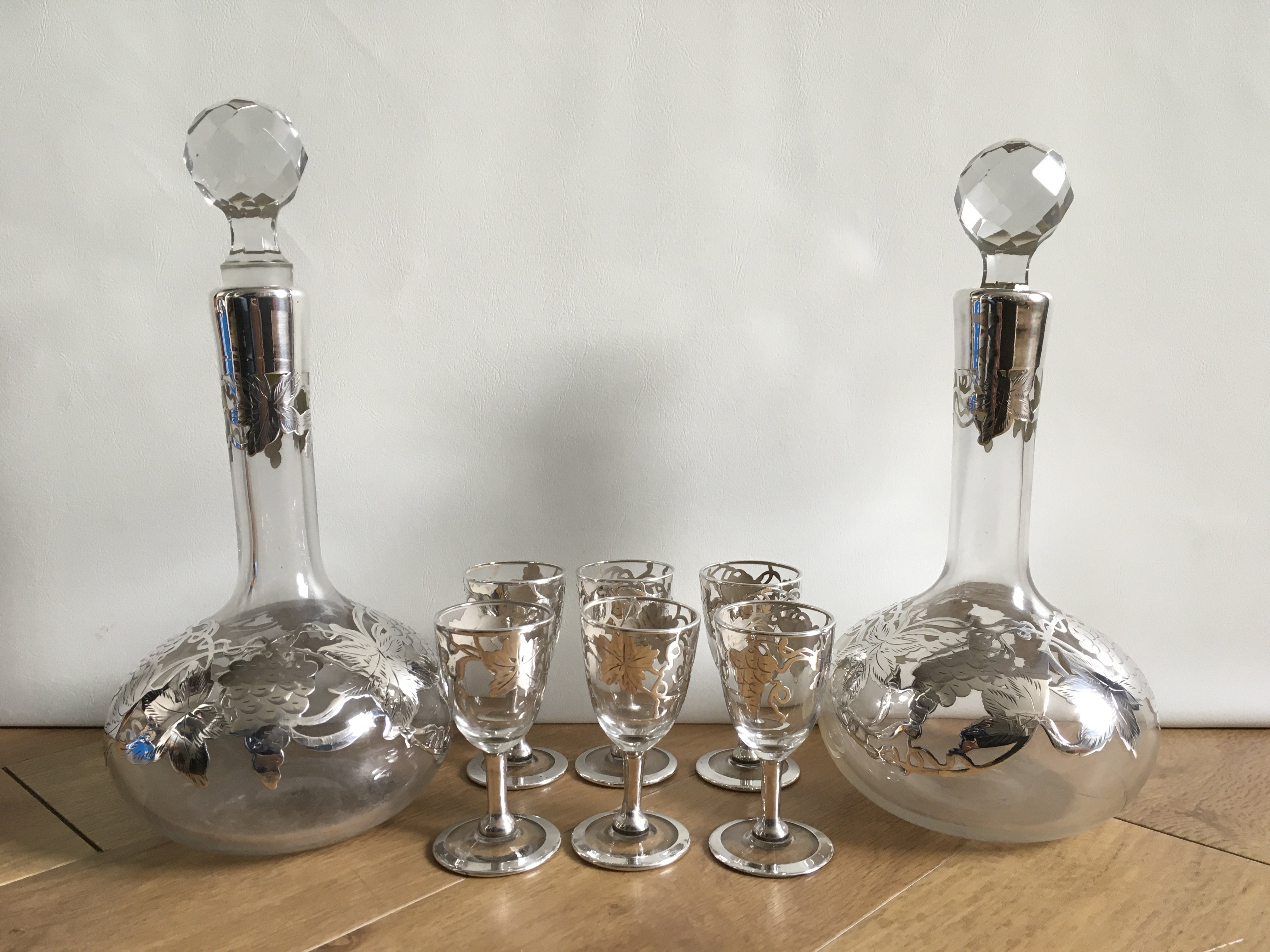 Two antique liqueur decanters with silver overlay