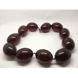 A large, heavy, cherry coloured bead necklace, app