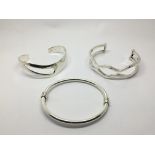 Three silver bangles.