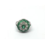 A platinum, emerald and diamond daisy style ring s