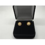 A pair of 9ct gold earrings set with a central dia