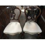 A pair of Victorian dining chairs the carved top r