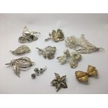 A collection of ten silver brooches.