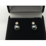 A pair of 9ct white gold earrings set with a centr