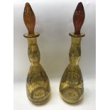 A pair of Edwardian amber glass etched decanters.