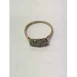 A 18 ct gold ring inset with a row of three small