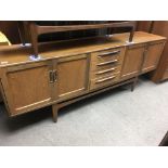 A G plan sideboard fitted with four drawers flanke