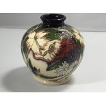 A Moorcroft vase decorated with wild flowers and f