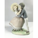 A Lladro figure of a young courting couple. Height