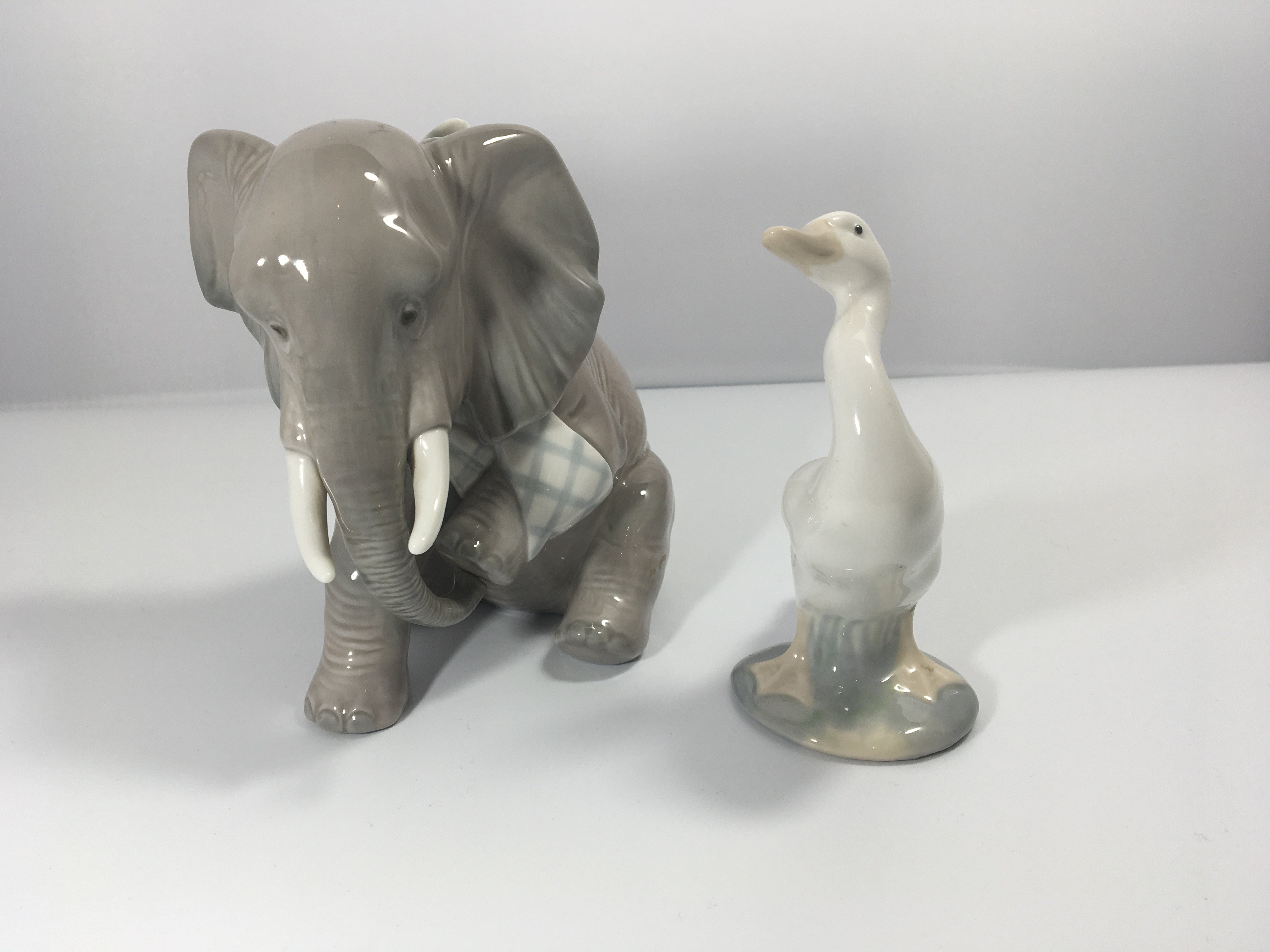 A Lladro figure of an elephant with bandaged leg a