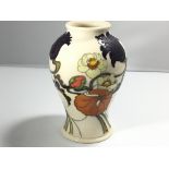 A Moorcroft vase decorated with flowers on a white