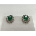 A pair of 9ct yellow gold emerald and diamond stud