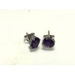 A pair of silver studs set with amethyst.