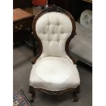 A Victorian walnut ladies chair with a carved top