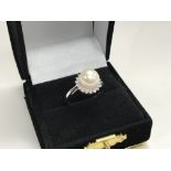 A 9ct white gold diamond and pearl ring.